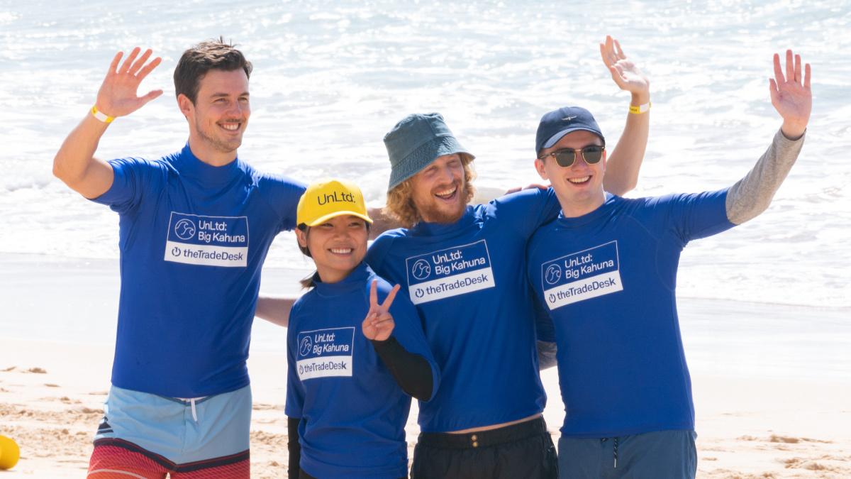 The Trade Desk employees waving on a beach