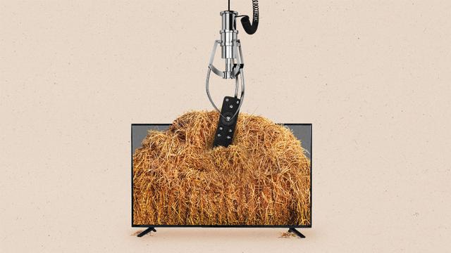 A roboting claw machine claw picks up a streaming remote from a pile of hay.