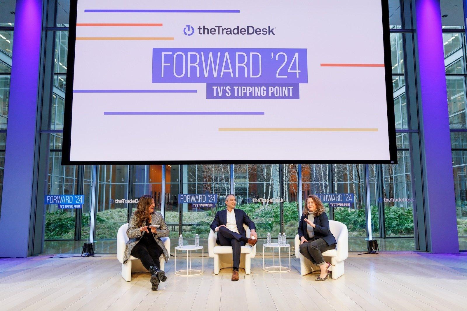 Forward '24 event hosted by The Trade Desk featuring three individuals talking in chairs in front of a screen.